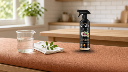 Plant-based surfactants explained: a stain remover spray and a glass beaker on a terracotta fabric bench in a kitchen